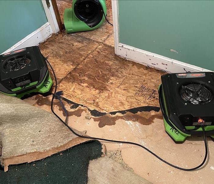 three air mover machines around a wet spot on the subfloor